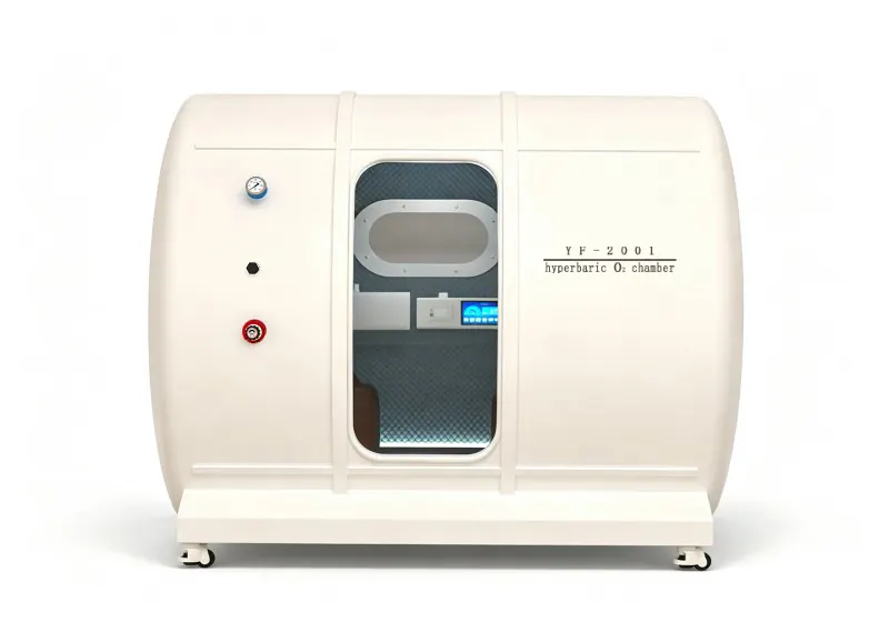 Cream hard shell hyperbaric chamber with a transparent door, oval viewing window, padded interior and pressure gauge.